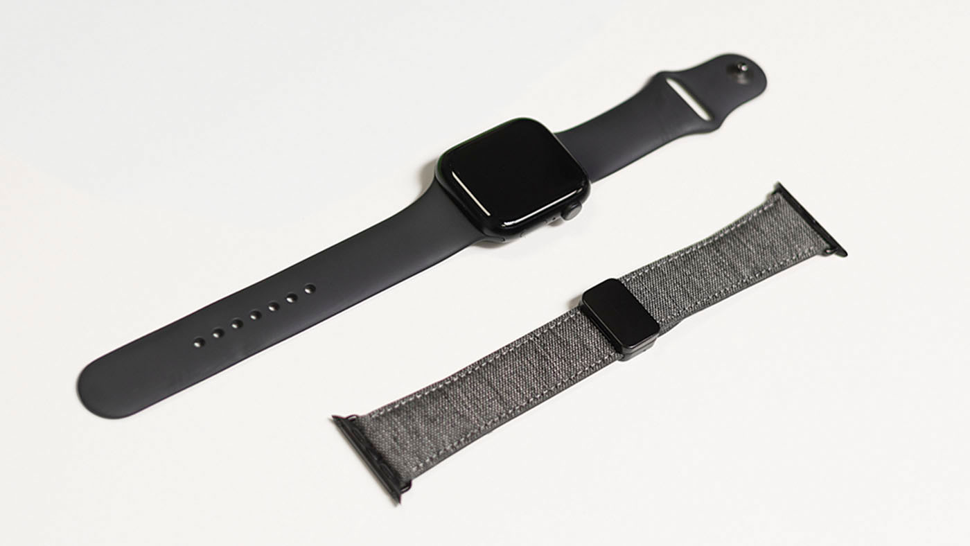 Die Apple Watch mit altem Armband liegt mit einem neuen Armband auf dem Tisch